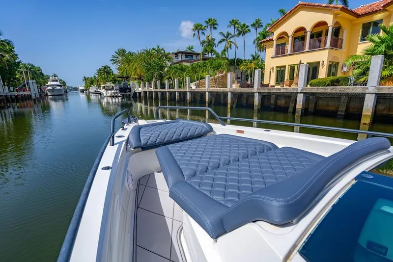 Slide: The Image of 2021 Axopar Brabus 37 Sun-Top boat cruising a scenic canal with luxury homes. - 12