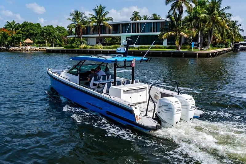 Slide: The Image of 2021 Axopar Brabus 37 Sun-Top cruising on a scenic waterway with palm trees. - 3