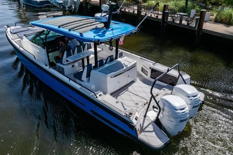 Slide: The Image of 2021 Axopar Brabus 37 Sun-Top boat with dual Mercury engines, docked in a marina. - 8
