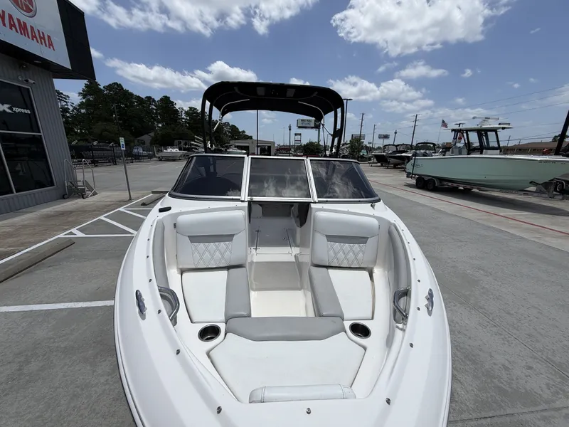 Slide: The Image of A white boat parked on a lot, featuring gray and white upholstery and a black canopy. - 22