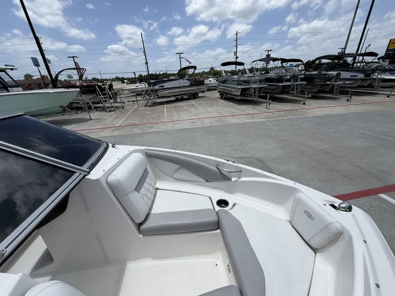 Slide: The Image of The image shows the cockpit of a 2019 Regal 1900ES SURF boat with white upholstery. - 19