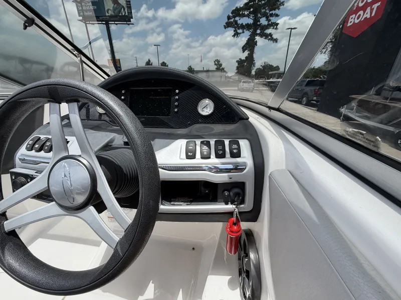 Slide: The Image of The image shows the cockpit of a 2019 Regal 1900ES SURF boat with a modern steering wheel and dashboard. - 17
