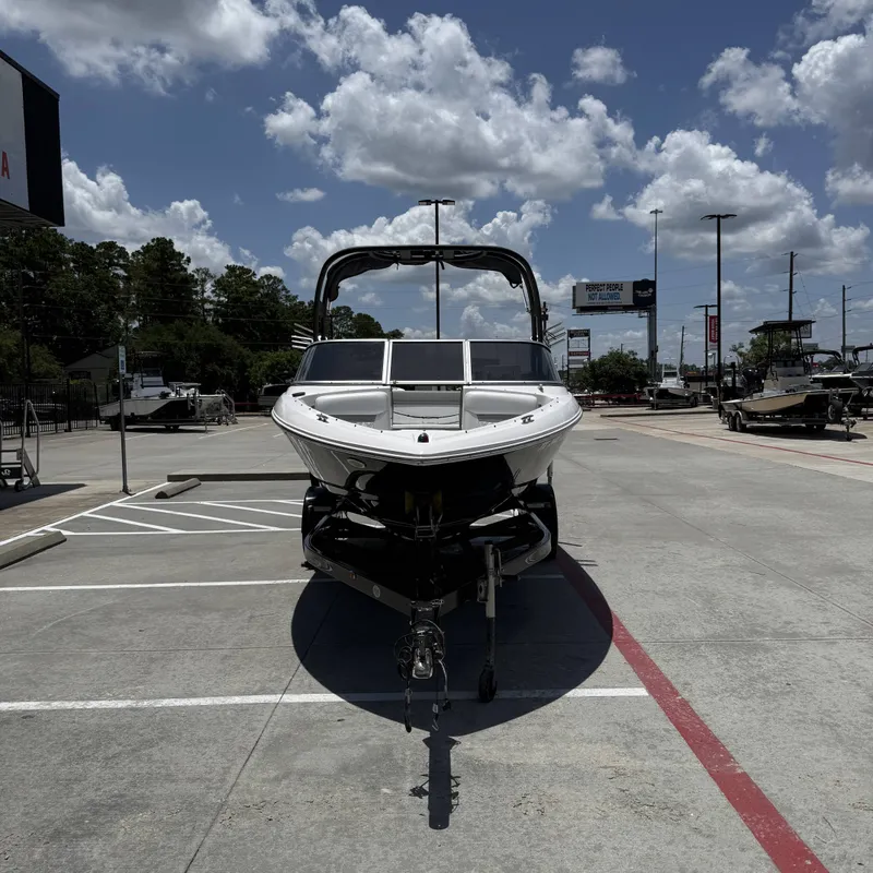 Slide: The Image of A 2019 Regal 1900ES SURF boat on a trailer in a parking lot under a blue sky. - 5