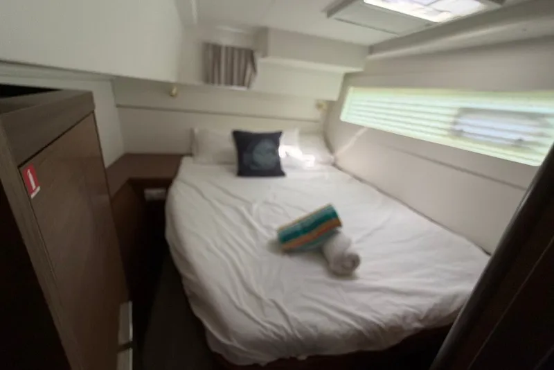 Slide: The Image of Cozy cabin interior of 2020 Lagoon 40 catamaran with bed and window. - 18