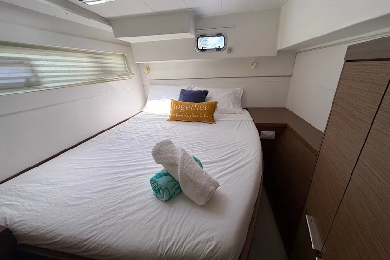 Slide: The Image of Cozy bedroom interior of 2020 Lagoon 40 yacht with neatly arranged bed and towels. - 24