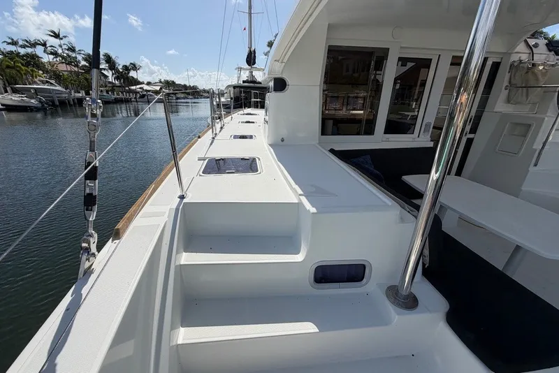 Slide: The Image of 2020 Lagoon 40 catamaran deck view, docked in a serene marina setting. - 26