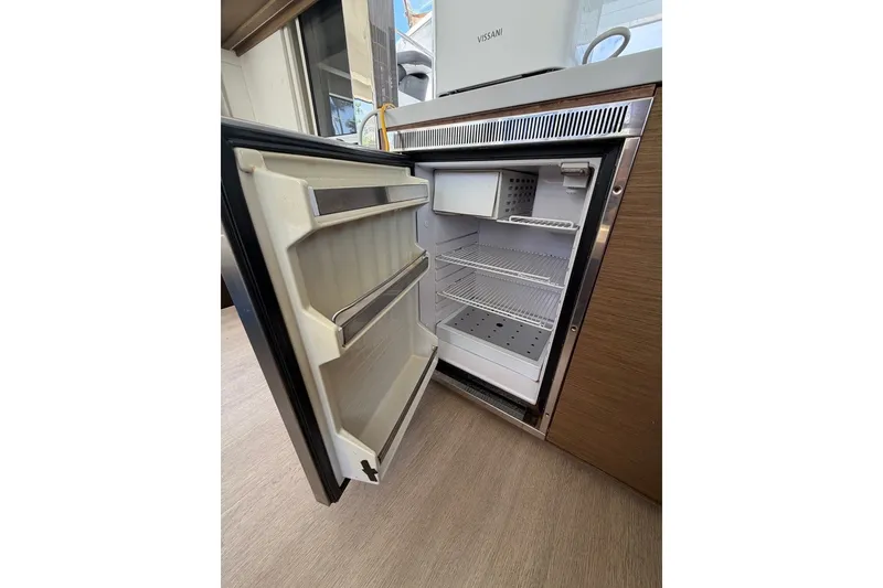 Slide: The Image of Open refrigerator inside a 2020 Lagoon 40 yacht, showcasing shelves and door storage. - 9