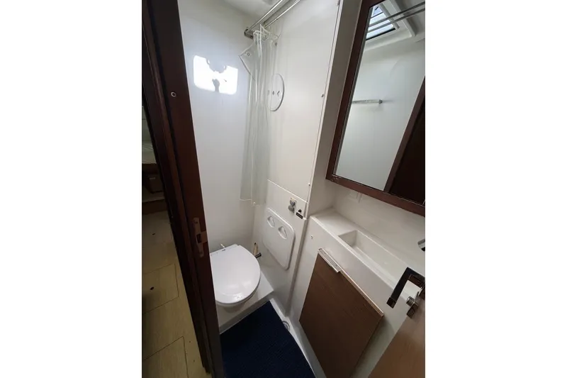 Slide: The Image of Bathroom interior of 2020 Lagoon 40 yacht, featuring toilet, sink, and mirror. - 19