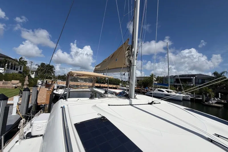Slide: The Image of 2020 Lagoon 40 catamaran docked, featuring sails and solar panel under a clear blue sky. - 29