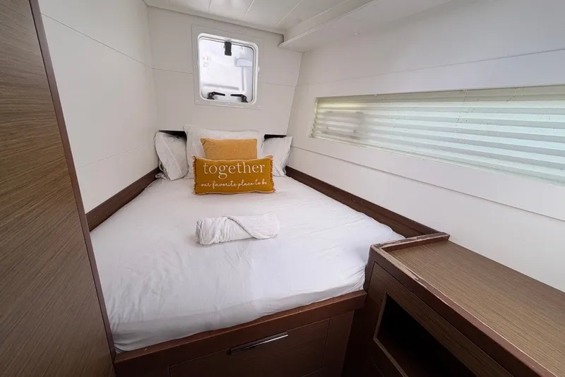 Slide: The Image of Cozy cabin interior of 2020 Lagoon 40 catamaran with bed and decorative pillows. - 15