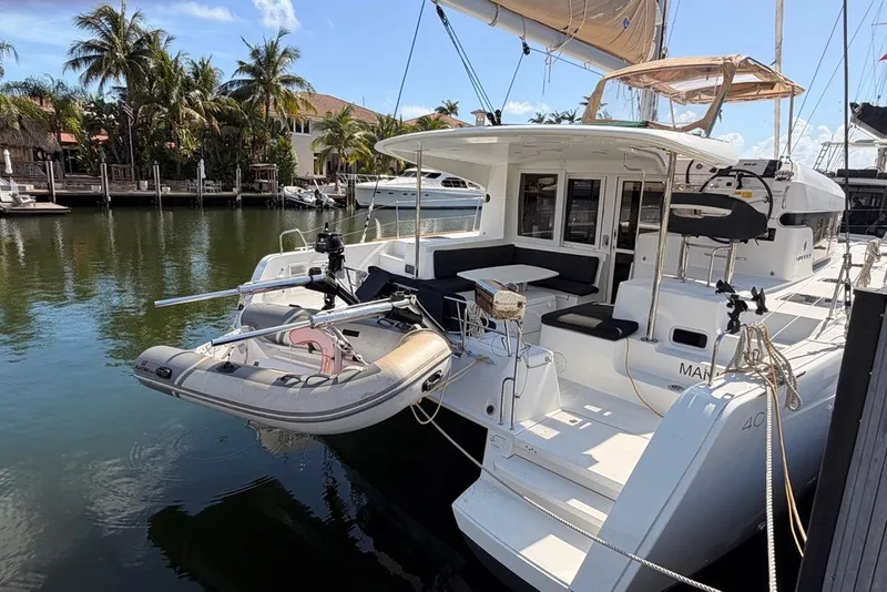 Slide: The Image of 2020 Lagoon 40 catamaran docked, featuring spacious deck and inflatable dinghy. - 33