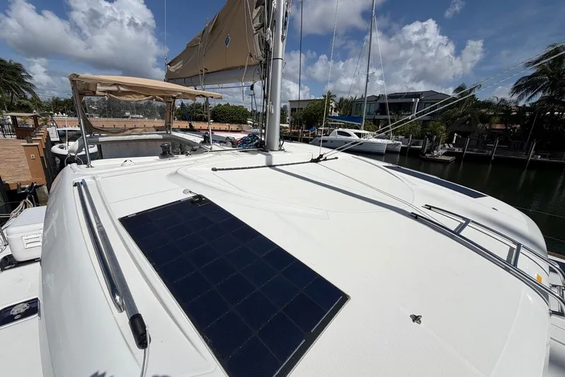 Slide: The Image of 2020 Lagoon 40 catamaran with solar panel, docked under a clear blue sky. - 28