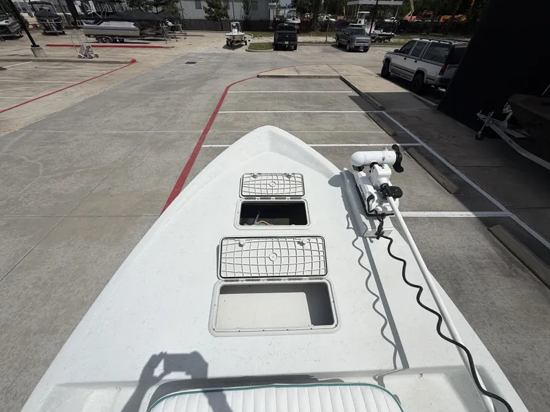 Slide: The Image of The image shows the bow deck of a Mowdy C-25 boat with two hatches and a trolling motor. - 23