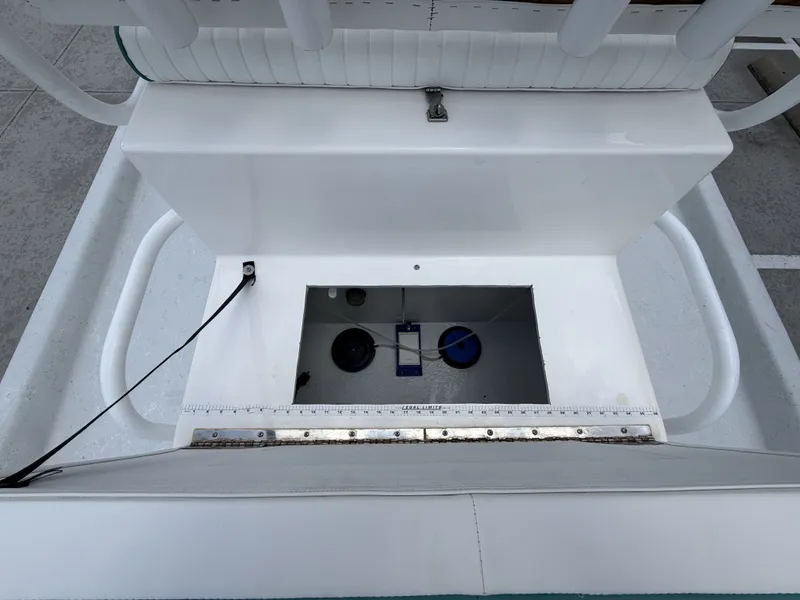 Slide: The Image of An open storage compartment on a 2015 Mowdy C-25 boat, featuring a ruler along the edge. - 14