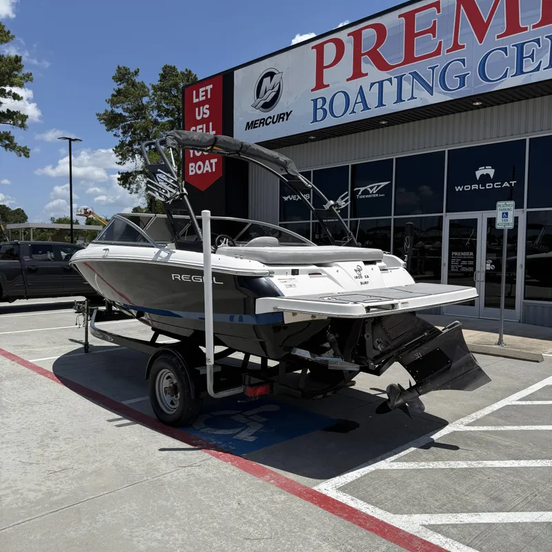 Slide: The Image of A 2019 Regal 1900ES SURF boat on a trailer outside a boating center. - 10