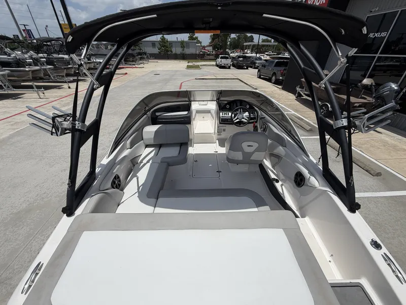 Slide: The Image of The image shows the cockpit of a 2019 Regal 1900ES SURF boat. It features white upholstery and a black bimini top. - 11