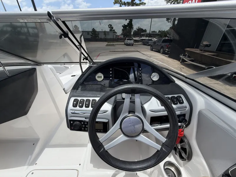 Slide: The Image of The image shows the cockpit of a 2019 Regal 1900ES SURF boat with a modern helm. - 15