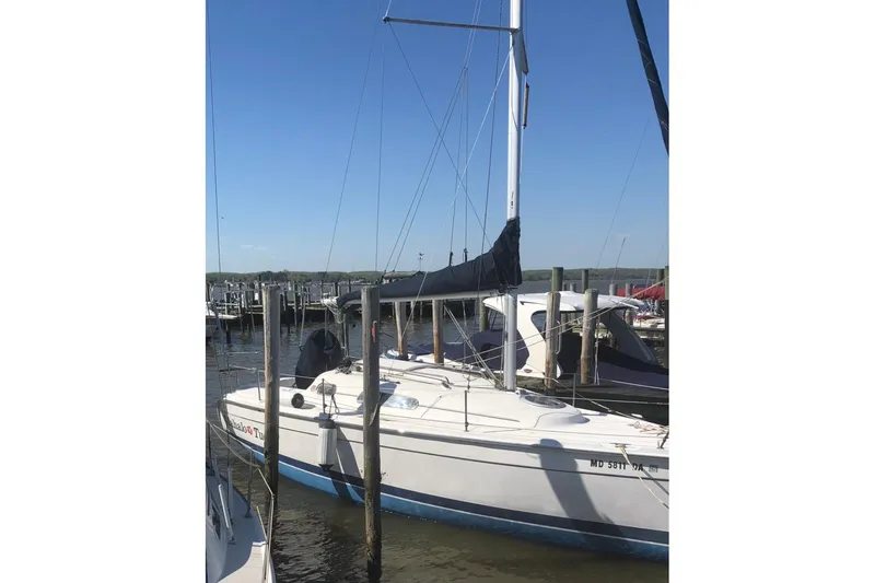 Slide: The Image of 2013 Marlow-Hunter 27 sailboat docked at a marina under clear blue skies. - 12