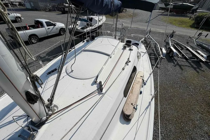 Slide: The Image of 2013 Marlow-Hunter 27 sailboat on gravel lot, with visible rigging and deck details. - 9
