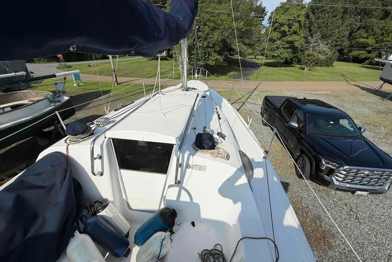 Slide: The Image of 2013 Marlow-Hunter 27 sailboat on land beside a black pickup truck. - 5