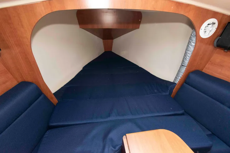 Slide: The Image of Interior cabin of 2013 Marlow-Hunter 27 sailboat with blue cushions and wooden accents. - 17