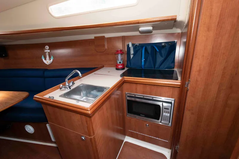 Slide: The Image of Compact galley in 2013 Marlow-Hunter 27 sailboat with sink, stove, and microwave. - 18