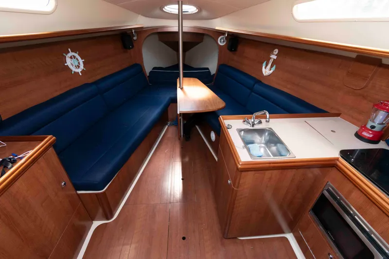 Slide: The Image of Interior of 2013 Marlow-Hunter 27 sailboat with wood finish and blue seating. - 15