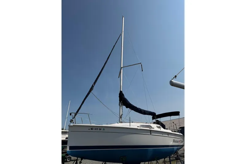 Slide: The Image of 2013 Marlow-Hunter 27 sailboat with mast, docked under clear blue sky. - 14
