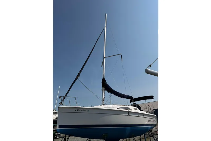 Slide: The Image of 2013 Marlow-Hunter 27 sailboat on land, mast up, clear sky background. - 13