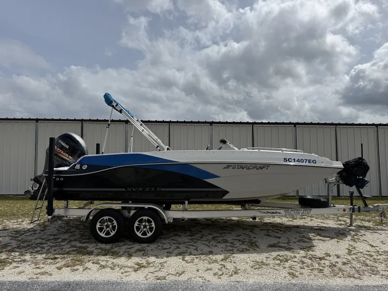 Slide: The Image of A 2023 Starcraft SVX 211 OB boat on a trailer in front of a building. - 3