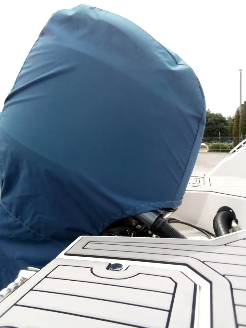 Slide: The Image of A boat's outboard motor covered with a blue cover. The deck is white with gray accents. - 17