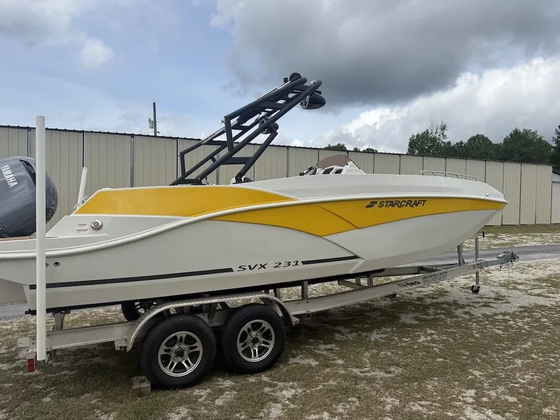 Slide: The Image of A yellow and white 2025 Starcraft SVX 231 OB boat on a trailer in front of a building. - 4