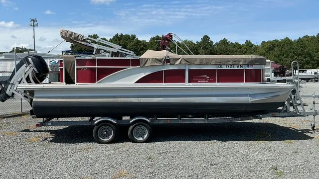 Slide: The Image of A 2018 Bennington 22 SLX TRI-LOG S CRUISE PREMIUM pontoon boat on a trailer in a gravel lot. - 3