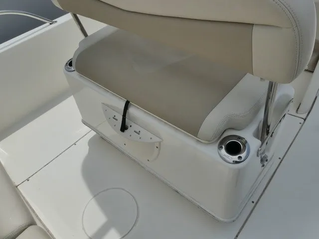 Slide: The Image of A beige cushion on a white boat seat with cup holders and storage underneath. - 6