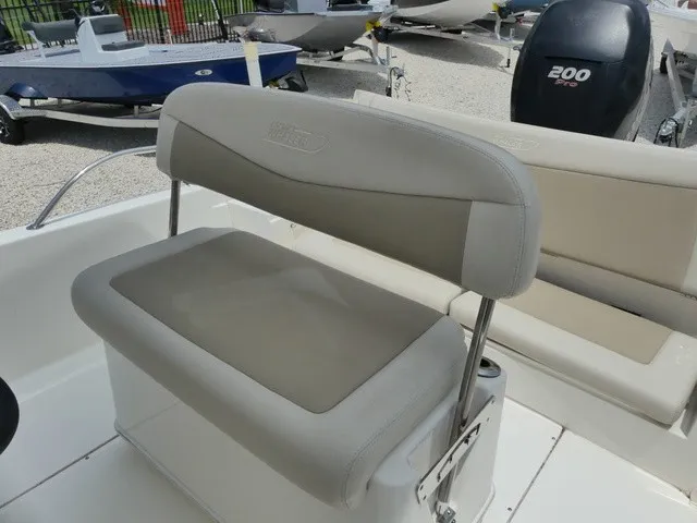 Slide: The Image of The 2018 Boston Whaler 210 Dauntless features a cushioned bench seat with backrest and an outboard motor. - 10