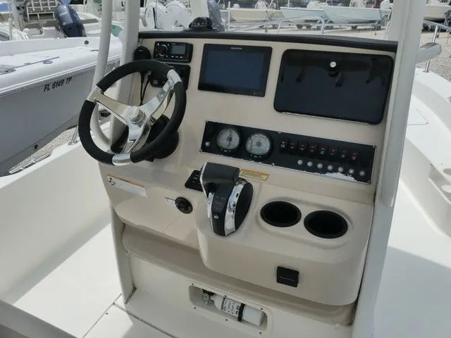 Slide: The Image of The image shows the helm of a 2018 Boston Whaler 210 Dauntless with a steering wheel and instruments. - 8