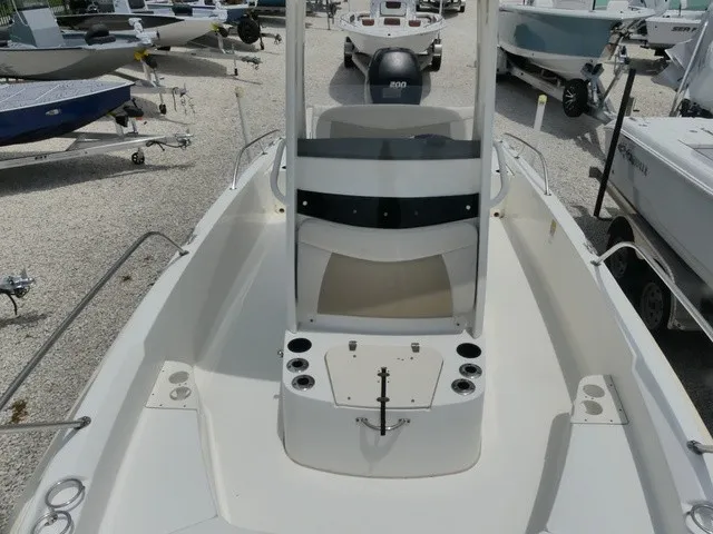 Slide: The Image of The image shows the deck of a 2018 Boston Whaler 210 Dauntless with a helm console and cup holders. - 12