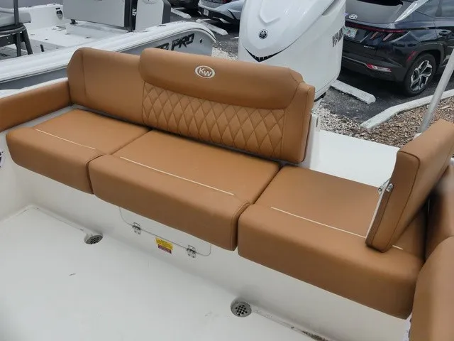 Slide: The Image of Key West 249 FS 2026: Brown cushioned bench seat in the boat with quilted pattern. - 5