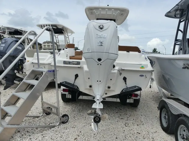 Slide: The Image of A 2026 Key West 249 FS boat with a powerful outboard motor, parked on a gravel lot. - 3