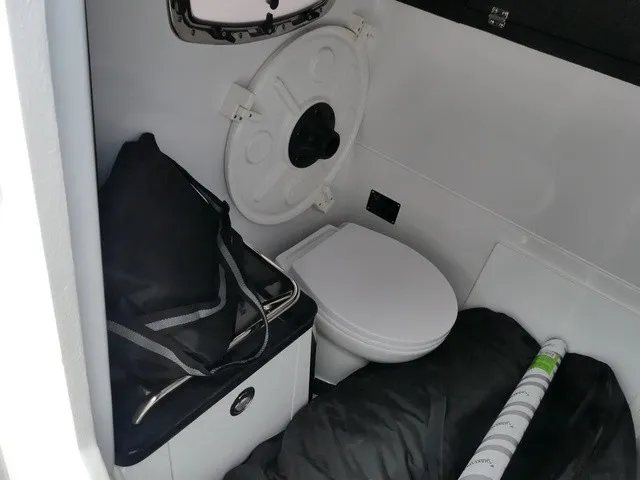 Slide: The Image of Interior of a 2027 Monterey Elite 30 OB with a toilet and storage area. - 20