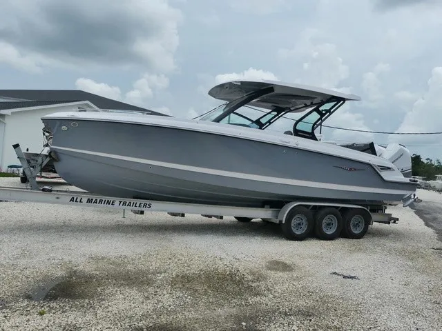Slide: The Image of A gray 2027 Monterey Elite 30 OB boat on a trailer in a gravel lot. - 4