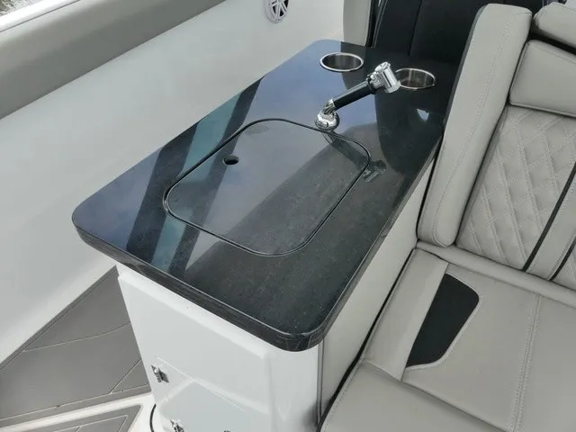 Slide: The Image of A sleek black countertop with a faucet and cup holders on a boat. - 10