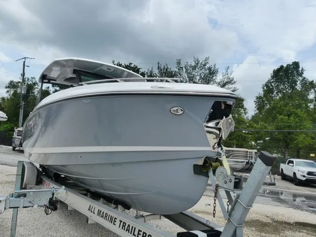 Slide: The Image of A Monterey Elite 30 OB boat on a trailer, surrounded by trees and cars. - 2