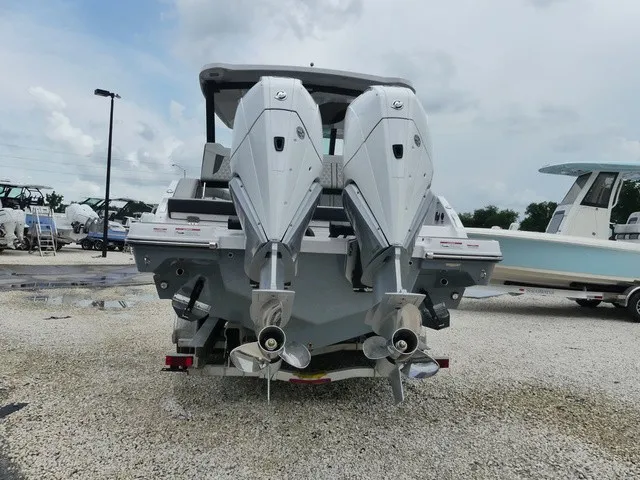 Slide: The Image of The image shows the rear of a Monterey Elite 30 OB with twin outboard engines on a gravel lot. - 5