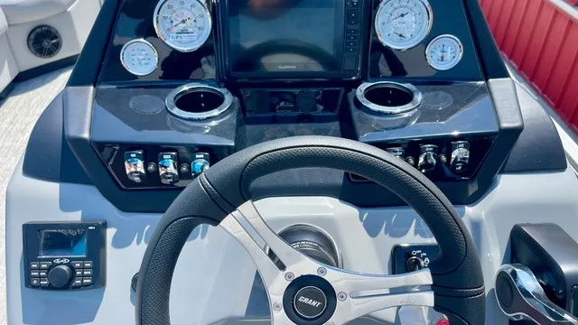 Slide: The Image of The image shows a boat's helm with a steering wheel, gauges, and cup holders. - 17