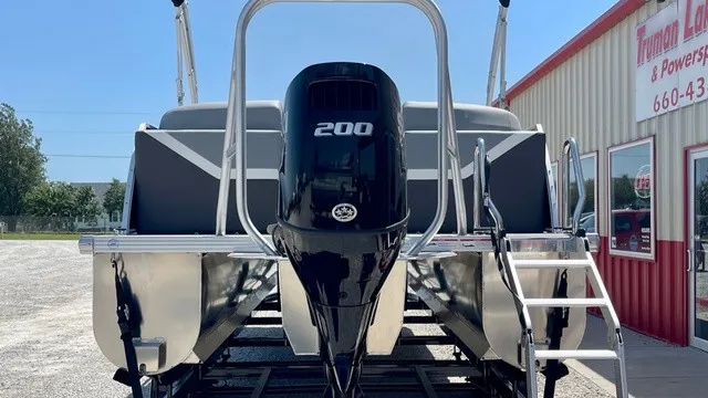 Slide: The Image of 2026 Landau Island Breeze 23C Sport with outboard motor, on a trailer in front of a building. - 21