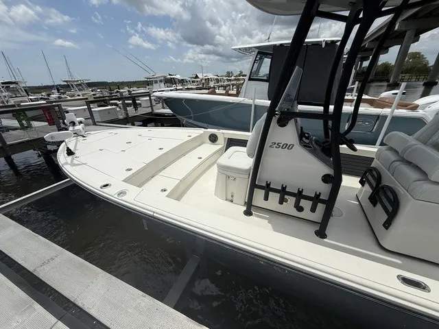 Slide: The Image of A white Pathfinder 2500 Hybrid boat docked. It features a spacious deck and seating area. - 17