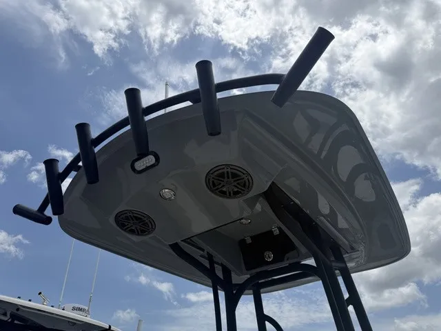 Slide: The Image of A T-top of a Pathfinder 2500 Hybrid with speakers and rod holders under a cloudy sky. - 13