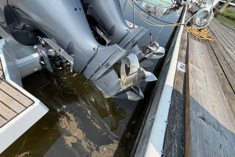 Slide: The Image of Twin outboard motors on a 2020 Jeanneau NC Sport 895 docked by wooden pier. - 73