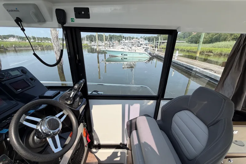 Slide: The Image of Interior view of 2020 Jeanneau NC Sport 895 boat cockpit with marina in background. - 26